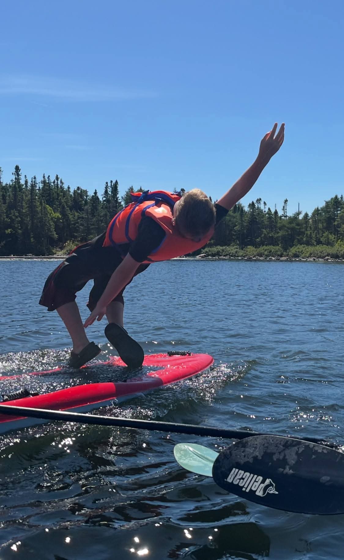 A beginner paddle boarder balancing on Neil's Pond in Paradise, Newfoundland.