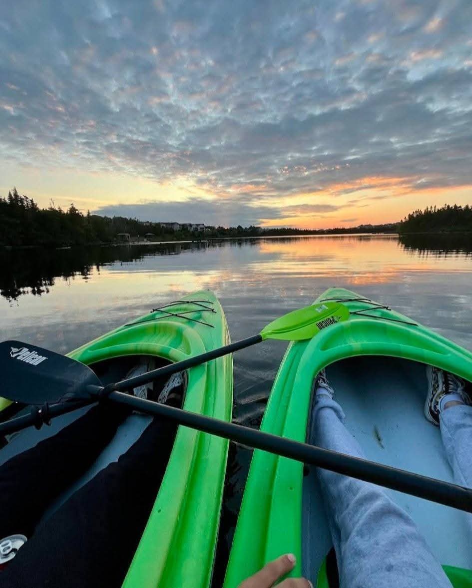 A Paradise Paddles kayak on calm Neil's Pond near sunset.